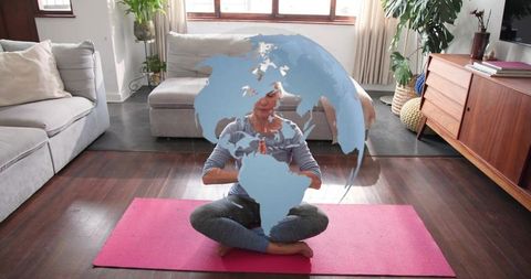 Mature woman meditating on yoga mat with translucent globe overlay for global mindfulness