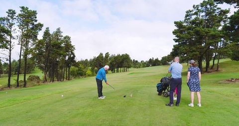 Senior golf enthusiasts enjoying leisure game on lush green course