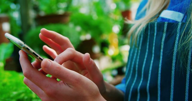 Mid section of woman using mobile phone in greenhouse - Download Free Stock Photos Pikwizard.com