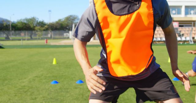 Soccer Player Training on Green Field with Orange Vest - Download Free Stock Images Pikwizard.com