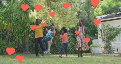 Happy Family Jumping in Garden with Heart Symbols