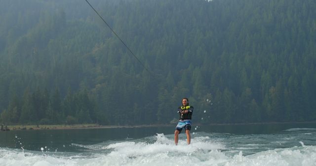 Person Wakeboarding on Lake in Front of Pine Forest - Download Free Stock Images Pikwizard.com