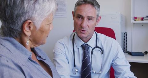 Doctor Providing Treatment Details to Concerned Senior Woman in Clinic