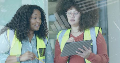 Diverse female architects discussing digital blueprint strategy