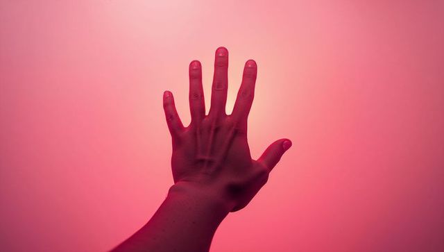 Hand Reaching Towards Gradient Backdrop in Pink Hue