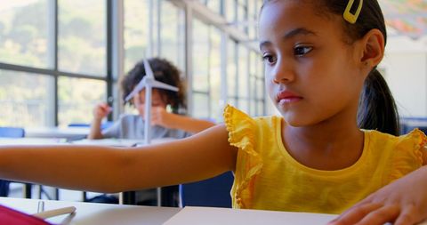 Young girl studying in bright classroom setting