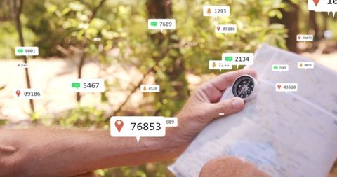 Hiker holding map and compass with digital navigation icons