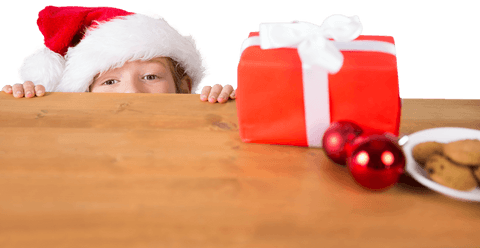 Child in Santa Hat Peeking Over Table with Christmas Gift Transparent