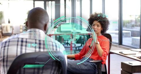 Businesswoman and colleague analyzing holographic HUD interface in collaborative office