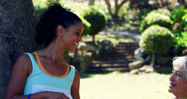 Smiling Woman Conversing Outdoors in Sunny Park - Download Free Stock Images Pikwizard.com