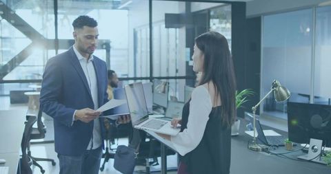 Business Professionals Collaborating with Documents and Laptop in Modern Office