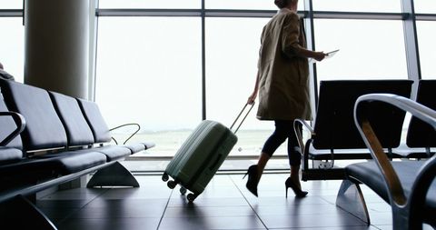 Businesswoman with Luggage Navigating Airport Terminal
