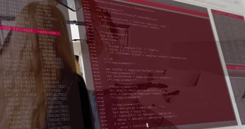 Developer workstation reflecting coworkers in jackets with red terminal displaying code