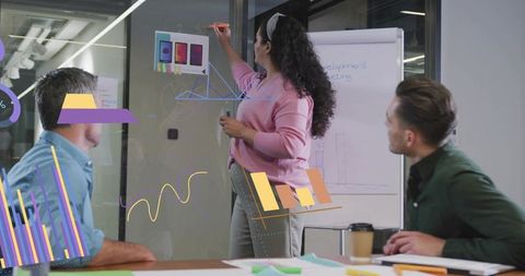 Woman Presenting Data Using Marker and Flipchart in Modern Meeting Room