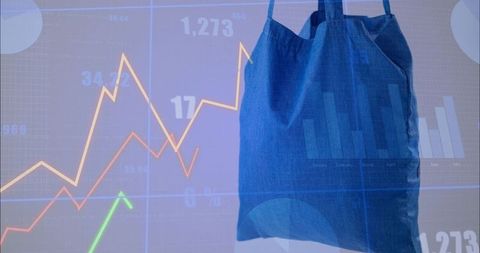Blue canvas tote bag hanging overlaid with financial charts and colorful line graphs