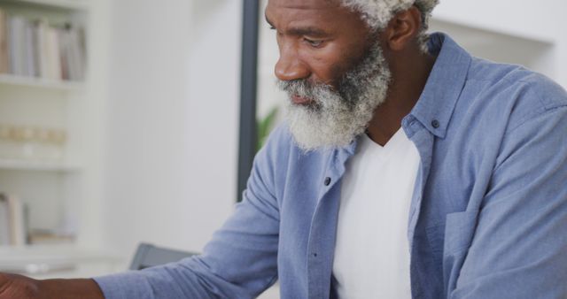 Image of sad african american senior man with eating toast. retirement lifestyle, spending time alone at home concept digitally generated image.