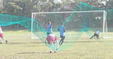 Youth soccer players defending goal during match with teal analytics overlay