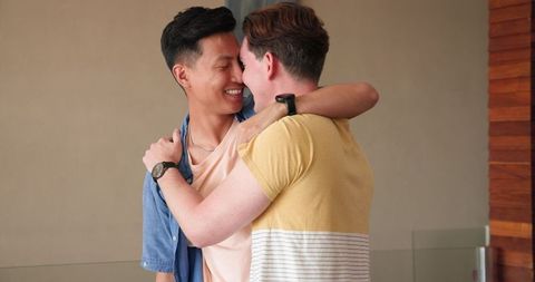 Cheerful couple embracing in diverse relationship at home