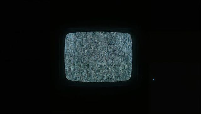 Glowing Retro CRT Television Displaying Blue-Gray Static in Dark Basement with Power LED