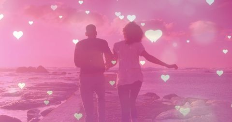 Romantic Couple Running with Hearts Overlay at Seaside
