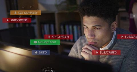 Young man focusing at monitor with social media notification overlays for remote work