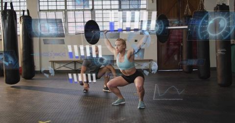 Female athlete performing overhead squat with barbell and AR fitness analytics in gym