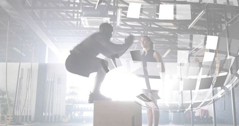 Athlete performing explosive plyo box jump while coach monitoring form with tablet