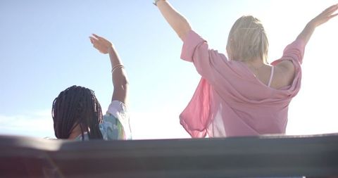 Joyful Women Enjoying Convertible Road Trip in Sun
