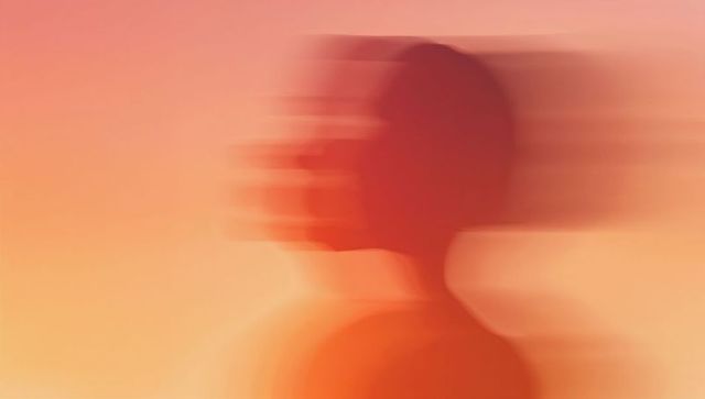 Abstract motion-blur female profile in warm sunset gradient with trailing glow