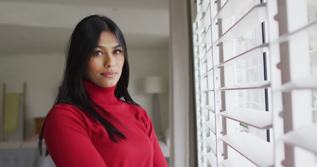 Image of happy of biracial woman standing at window. Lifestyle, spending free time at home concept.