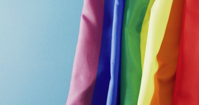 Image of rainbow fabric over blue background with copy space. Gender, lgbt, queer, gay pride and equality concept.