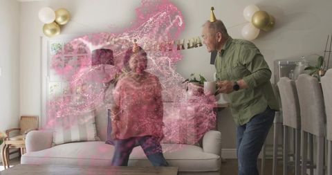 Senior chinese couple celebrating birthday at home with pink powder burst and balloons