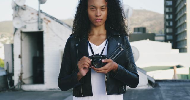 Confident Photographer Holding Camera on Rooftop - Download Free Stock Images Pikwizard.com