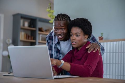 Happy Couple Planning Online Together at Home