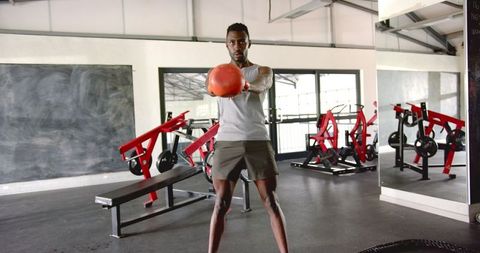 Athletic Man Holding Red Medicine Ball for Strength Training