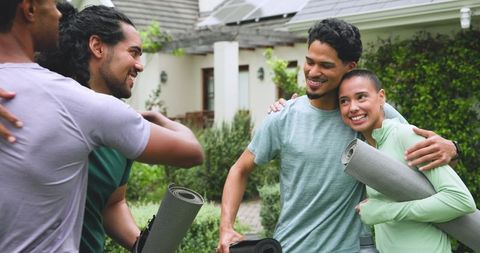 Diverse Couple Embracing with Yoga Mats at Vibrant Outdoor Gathering