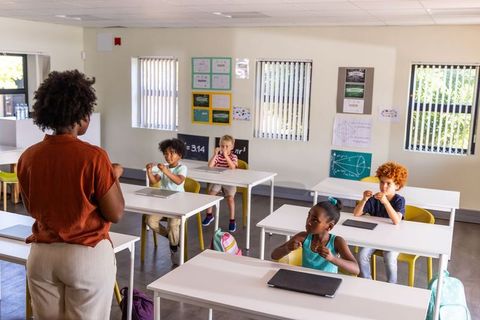 African American Teacher Leading Elementary Math Lesson with Students and Tablets