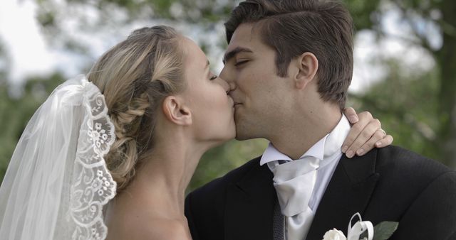 Groom kissing his pretty new wife in a park on their wedding day - Download Free Stock Photos Pikwizard.com