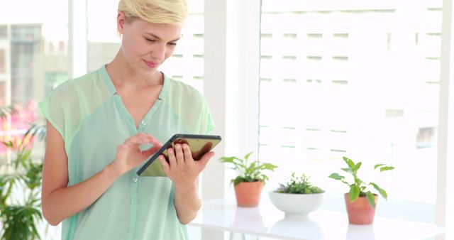 Young woman using tablet in bright office space - Download Free Stock Images Pikwizard.com