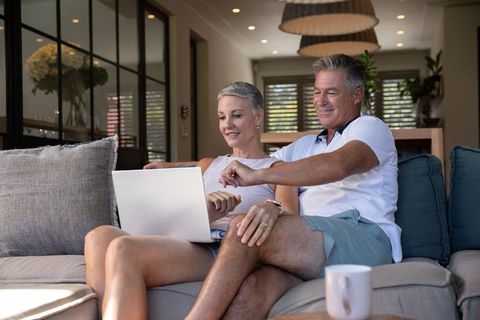 Senior Couple Relaxing on Couch with Laptop in Modern Living Room