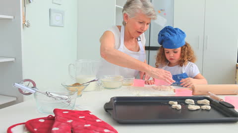 Grandmother Teaching Granddaughter Baking through Joyful Bonding