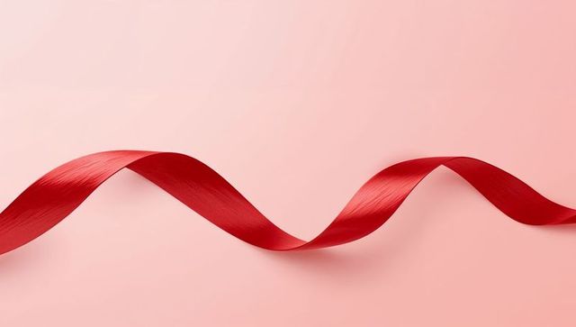 Flowing Red Satin Ribbon Curving S-Shape on Soft Pink Background for Festive Design