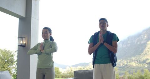 Couple Meditating Outdoors with Mountains in Background