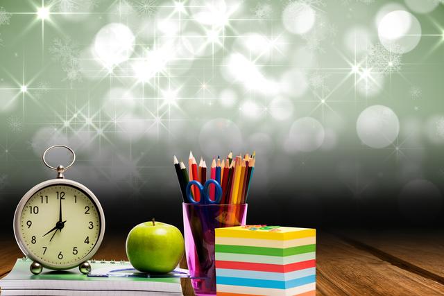 This image features an arrangement of school supplies including an alarm clock, colored pencils in a holder, an apple, and sticky notes on a wooden desk with a starry background. Ideal for educational materials, back-to-school promotions, classroom decor, and time management concepts.