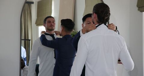 groomsmen adjusting attire in mirror for wedding preparation - Download Free Stock Images Pikwizard.com