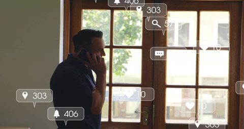 Backlit man talking on smartphone by wooden glass door indoors with notification overlays