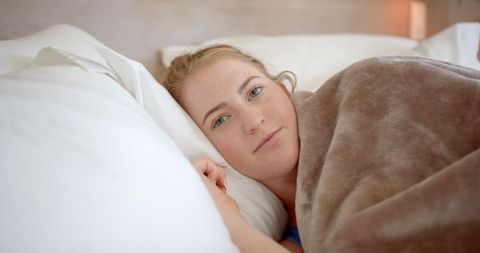 Woman Relaxing Cozy in Bed Under Soft Blanket