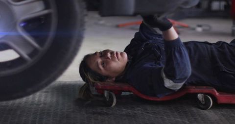 Mechanic Inspecting Vehicle Underside with Focused Precision