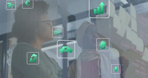 Diverse team collaborating on sustainable innovation with green tech icons on glass