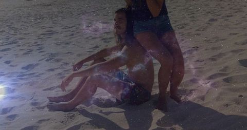 Sunlit beach couple relaxing with nebula overlay and lens flare, dreamy summer scene